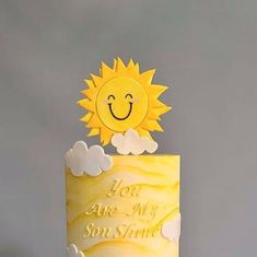 a yellow and white cake with a smiling sun on top that says, you are my son's sunshine