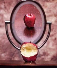 an apple sliced in half sitting on top of a wooden table