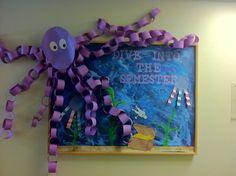 an octopus is hanging on the wall next to a bulletin board