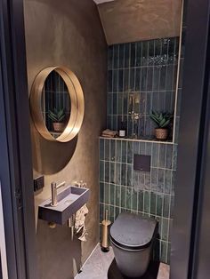 a bathroom with a toilet, sink and mirror on the wall next to each other