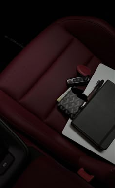 the interior of a car with a notebook, pens and other items sitting on it