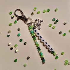 a keychain with the word arrow on it surrounded by green and white beads