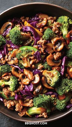 a bowl filled with broccoli, mushrooms and red cabbage on top of a table