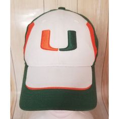 a white and green hat with the letter u on it sitting on top of a table