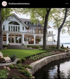 a large white house sitting on top of a lush green field next to a lake