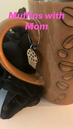 a cup with a keychain hanging from it's side and the words, muffins with mom