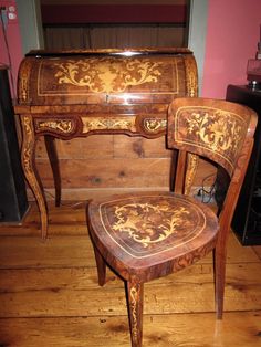 an antique desk and chair are sitting on the floor