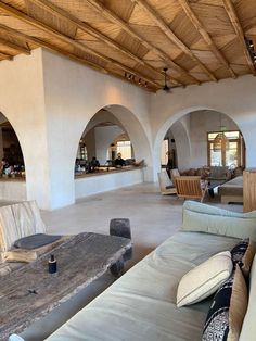 a living room filled with furniture and lots of wood beams on top of the ceiling