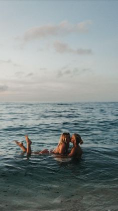 two people swimming in the ocean together