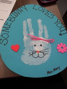 a handprint on a blue plate with a cat's face and pink heart