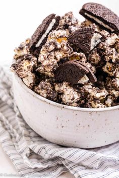 a bowl filled with oreo cookies and white chocolate chips on top of a towel