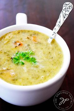 a close up of a bowl of soup on a table with a spoon in it