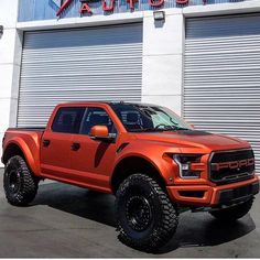 an orange truck parked in front of a building