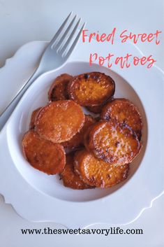 fried sweet potatoes in a white bowl on a plate with a fork and knife next to it