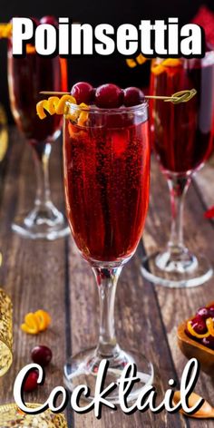 two glasses filled with red wine and garnished with orange peels on the side