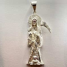 This elegant pendant features the image of the La Santa Muerte surrounded by rays of light. Comes in 925 sterling silver. Unique jewel is our exclusive design. Pendant Height: 3 inch Collectible Silver Spiritual Jewelry, Mystical Silver Pendant Jewelry, Mystical Sterling Silver Jewelry, Mystical Engraved Silver Jewelry, Spiritual Sterling Silver Halo Jewelry, Spiritual Sterling Silver Jewelry With Halo Detail, Sterling Silver Pendant With Halo Detail, Silver Pendant Jewelry With Shiny Finish, Silver Halo Round Pendant Jewelry