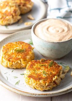 two crab cakes on a plate next to a cup of coffee