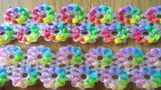 rainbow loom bracelets are lined up on a table with beads in the middle