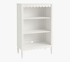 a white bookcase with scalloped edges on the top and bottom shelf is shown