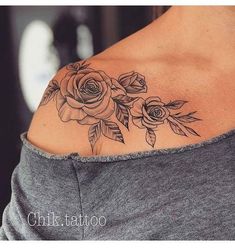 a woman's shoulder tattoo with roses on her left side and leaves on the back