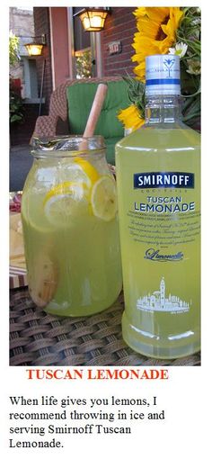 a bottle of lemonade sitting on top of a table next to a vase filled with sunflowers