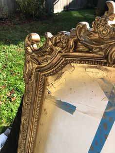 an old mirror sitting in the grass outside