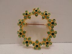 "Hello, here I have a vintage brooch pin, gold tone metal round with light green and dark green rhinestones.  The brooch is in very good condition, please see pictures as they are part of the description.  The measurements are, 1 3/8\" diameter. I accept best offers, just send me a message and I will get back with you promptly. I will ship your item within 24 hours, I take great care when packing your item for shipping so that it will make it to you safely. Thank you for stopping by and have a g Green Round Brooch For Formal Occasions, Green Round Brooches For Wedding, Green Round Brooch For Gift, Green Round Wedding Brooches, Green Round Brooches For Gift, Green Round Brooch, Elegant Green Rhinestone Brooches, Green Flower-shaped Brooch Pins, Crystal Champagne Flutes