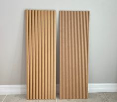 two tall wooden doors sitting next to each other in a room with tile flooring