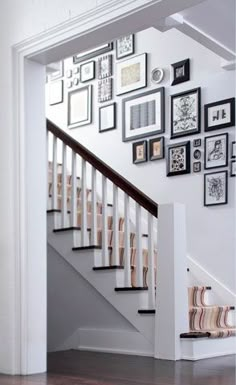 a staircase with many framed pictures on the wall