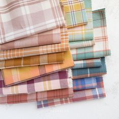 a pile of different colored plaid cloths