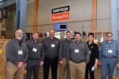 a group of men standing next to each other in front of a sign that says simpson strong time