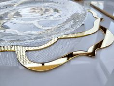 three decorative plates sitting on top of a table next to each other and gold trimmings