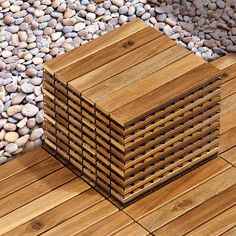 a stack of wooden boards sitting on top of a pile of gravel next to rocks