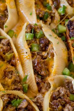 some pasta shells with meat, cheese and green peppers on them are ready to be eaten