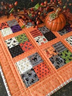 an orange and black quilt with pumpkins on it