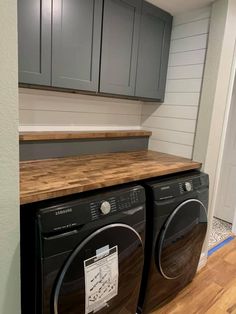 a washer and dryer in a room with wood flooring on the side