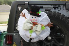 a snowman decoration hanging from the back of a truck