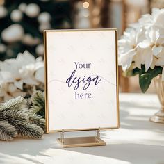 a sign sitting on top of a table next to white flowers and greenery in vases