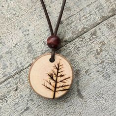 a wooden pendant with a tree design on it