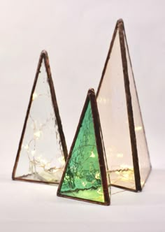 three triangular shaped glass pieces with lights in them