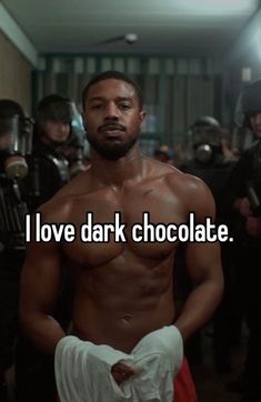 a shirtless man standing in front of a group of people with words that say i love dark chocolate