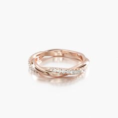 a rose gold ring with three diamonds on the top and bottom, set against a white background