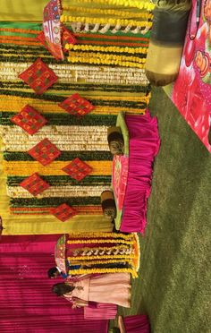 the woman is standing next to many colorful rugs