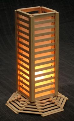 a tall wooden lantern sitting on top of a black floor next to a pile of logs