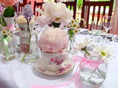 the table is set with pink and white flowers