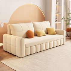 a living room with a white couch and brown pillows on the back of it's seat