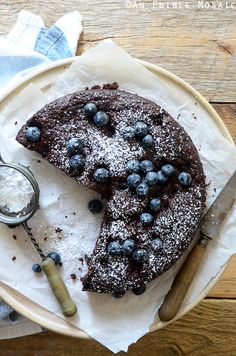 a chocolate cake with blueberries and powdered sugar