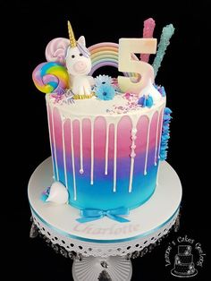 a birthday cake decorated with unicorns and rainbow colors