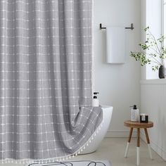 a bath room with a tub and a shower curtain in the corner, next to a window