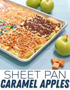 a sheet pan filled with caramel apples next to pretzels and marshmallows